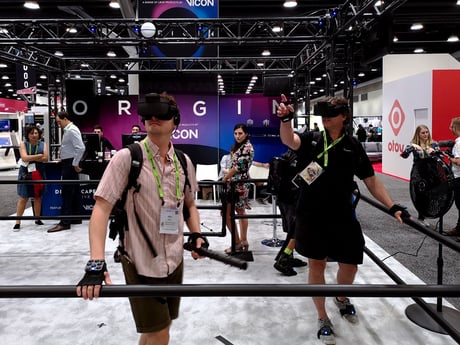 Three participants testing out experiences based on Vicon's multi-player VR system you can walk around in